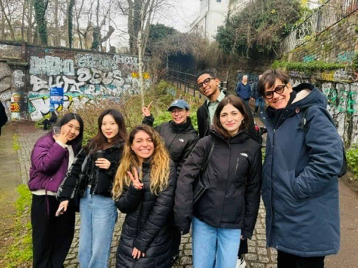 Eine Gruppe von Schülern, die in London an einer mit Graffiti übersäten Wand vorbeigeht
