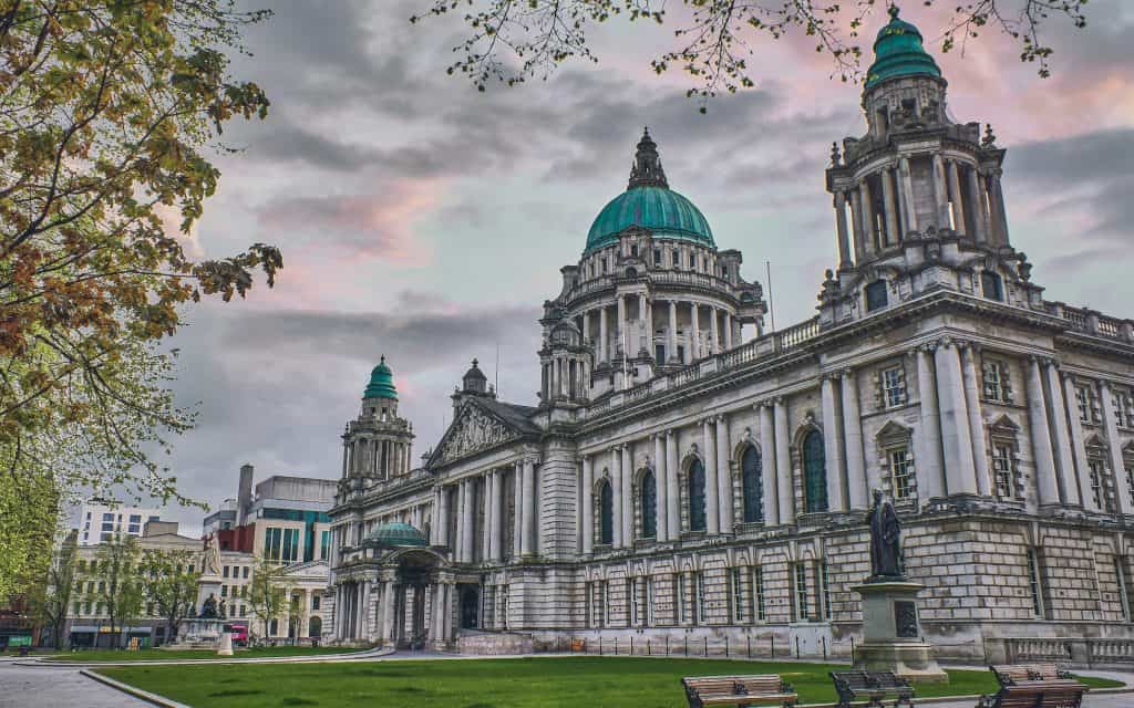 Belfast City Hall on a spring morning with green lawns and pink sky