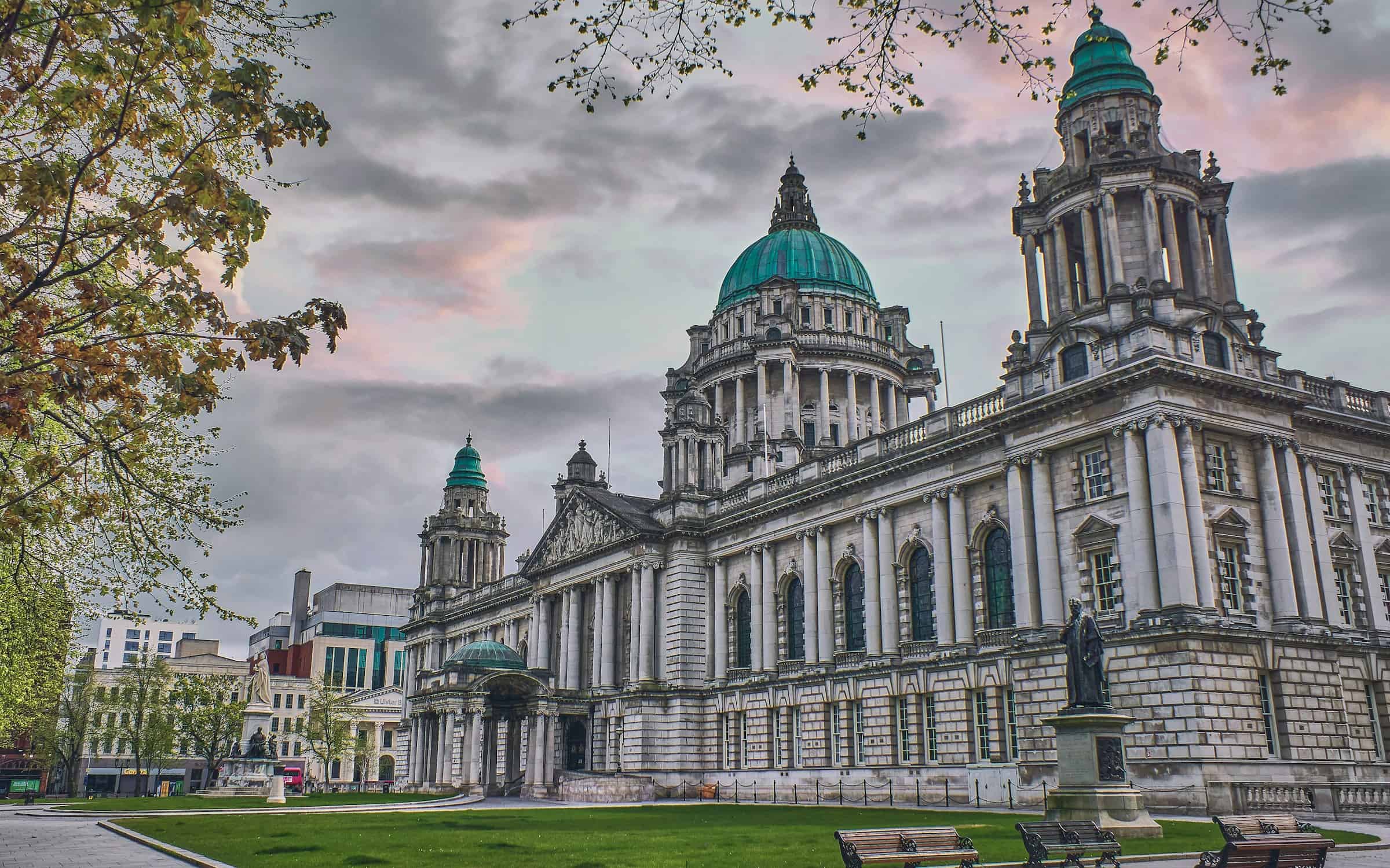 Belfast City Hall on a spring morning with green lawns and pink sky