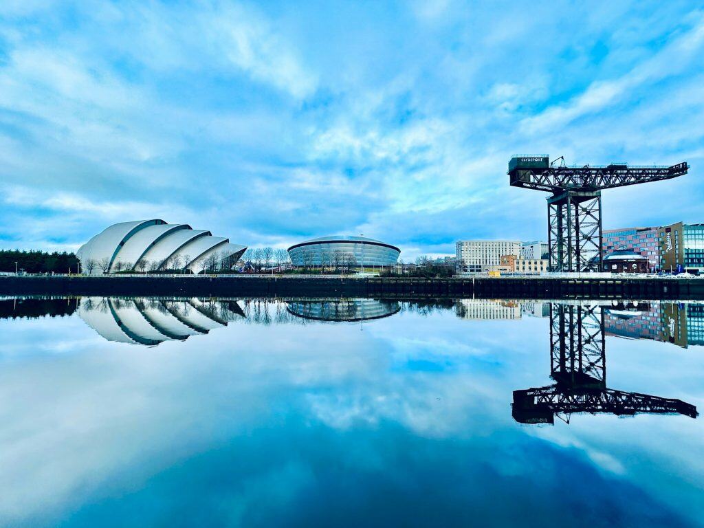 A mirror reflection of the OVO Hydro, SEC Armadillo and the Finnieston Crane on the River Clyde