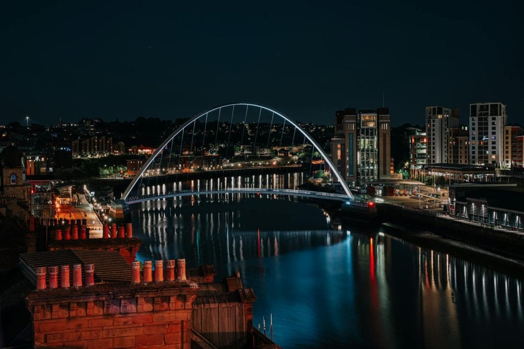 International students walking along Newcastle Quayside near the Tyne Bridge