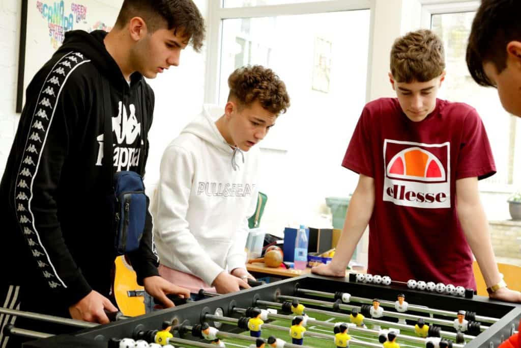 Teenage students playing table football during a social activity at ILC Colchester