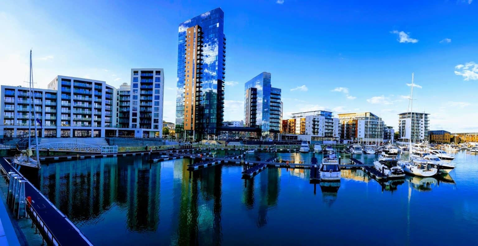 A marina filled with lots of boats next to tall buildings