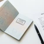 Open passport with UK entry stamp next to a visa application form