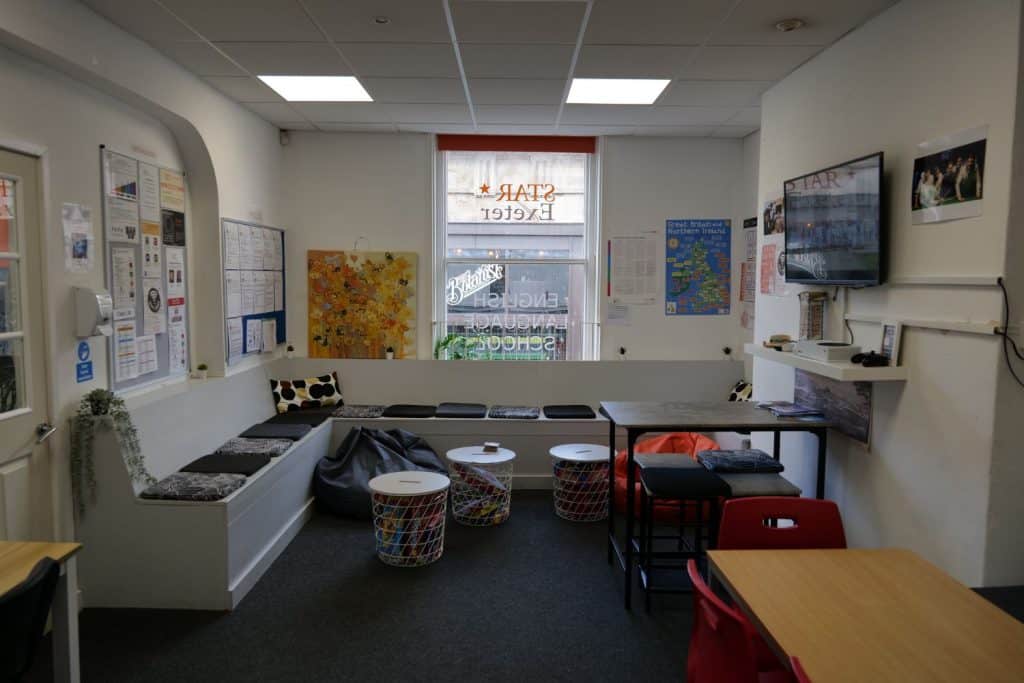 Aula vacía con mesas, una pantalla en la pared y un cartel en la ventana en STAR Exeter