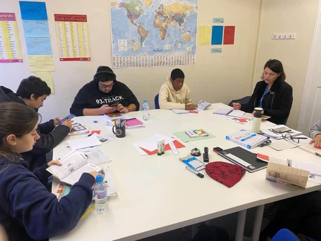 Estudiantes trabajando con apuntes y libros alrededor de una mesa en el Sheffield Language Centre