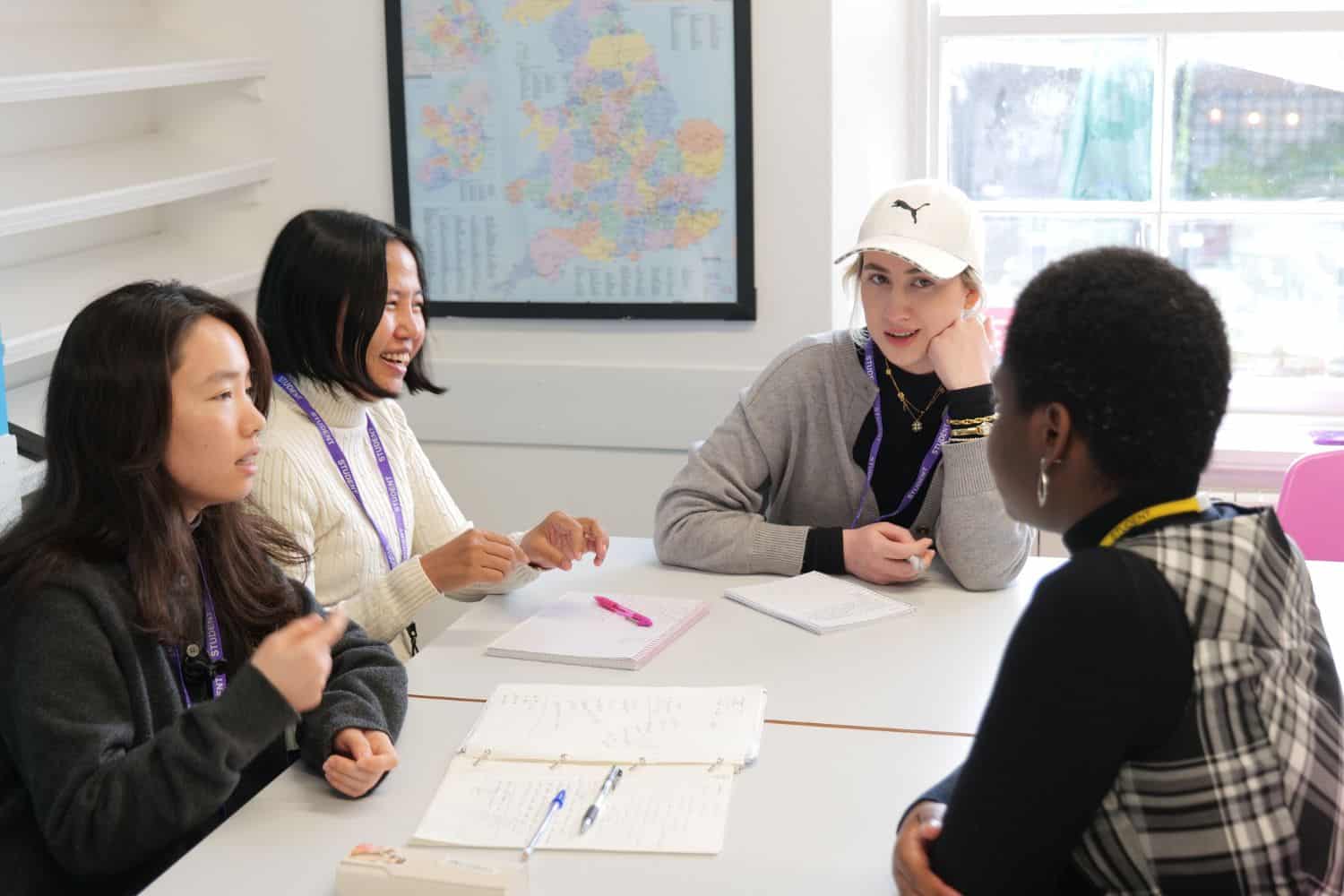 Estudiantes trabajando juntos en una mesa bajo un mapa del Reino Unido en STAR Exeter