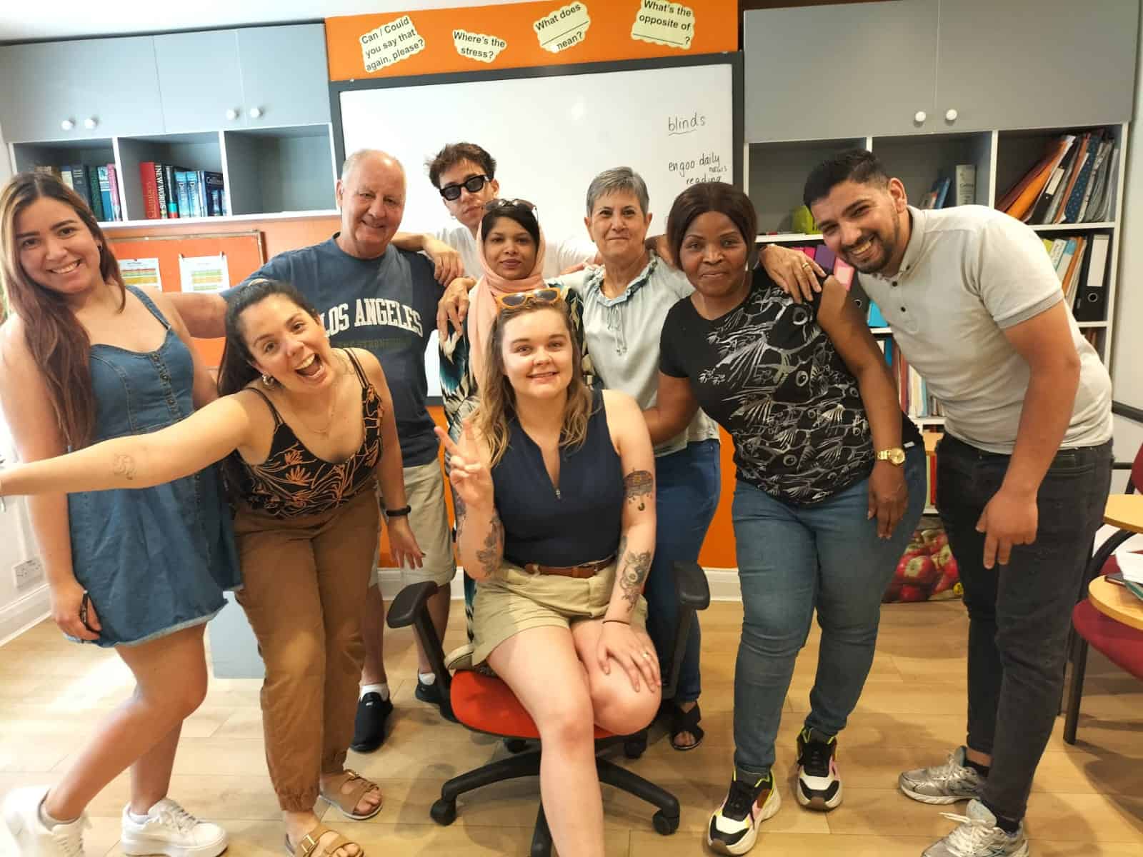 Group of smiling students and a teacher posing in an Ingla School of English classroom