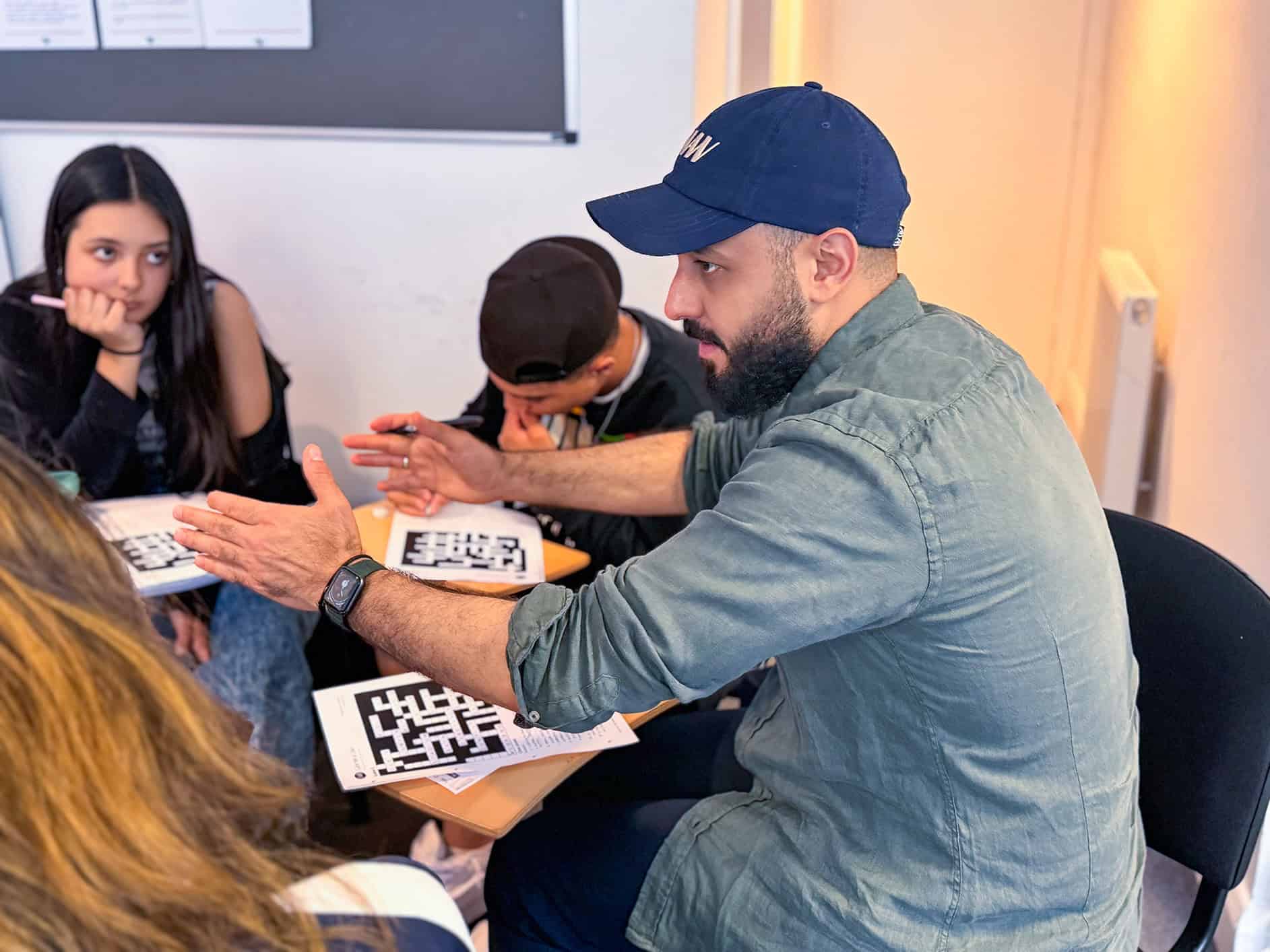 Un prof qui aide des élèves à faire une fiche d'exercices à The English Studio, à Londres