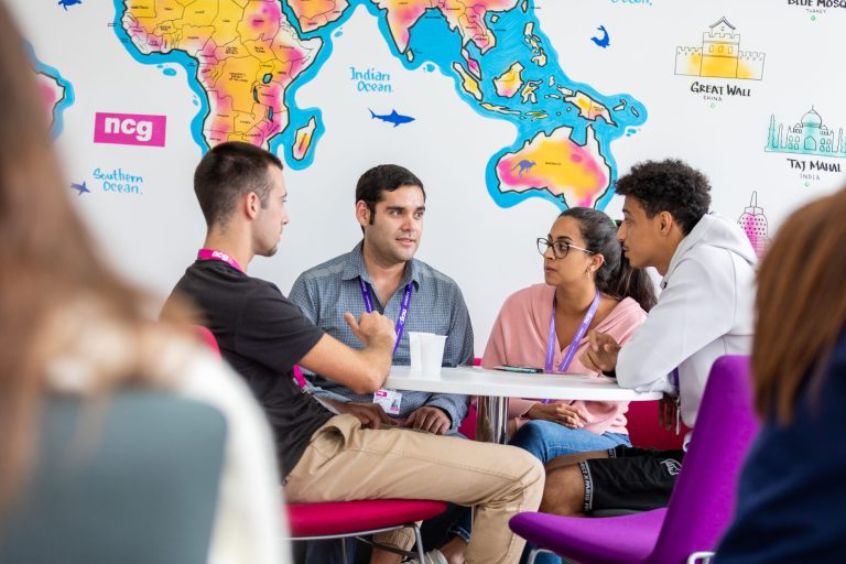 Students talking in the world-map classroom at NCG Liverpool